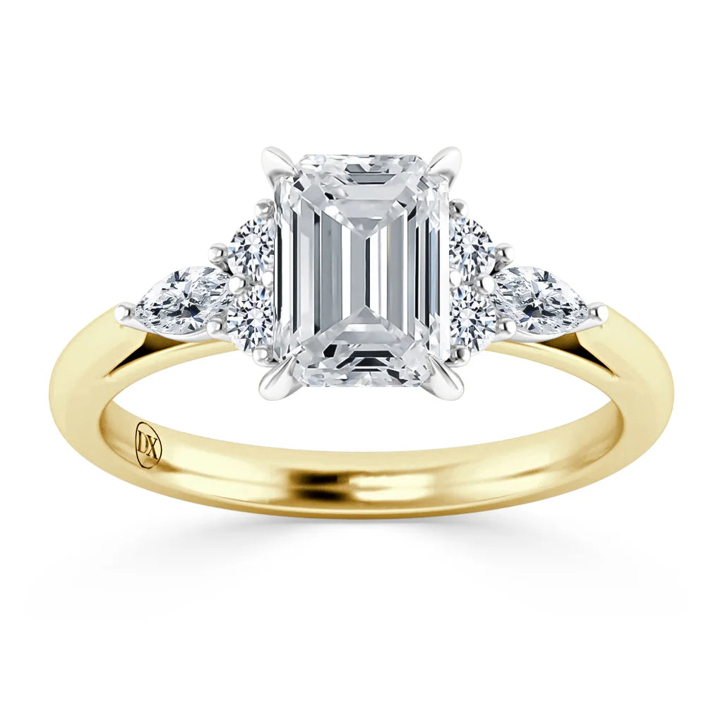 Emerald-cut diamond ring with side stones on a yellow gold band, viewed from the front.