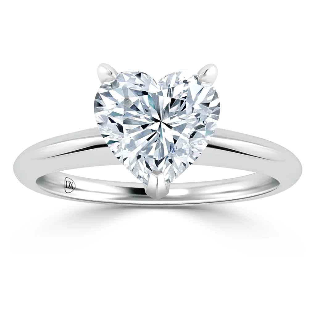 Platinum ring with a large, heart-shaped diamond solitaire on a simple polished band, shown on a white background.