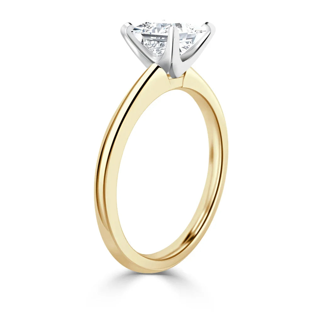 Gold band ring with a round solitaire diamond in a white gold prong setting, shown from the side.