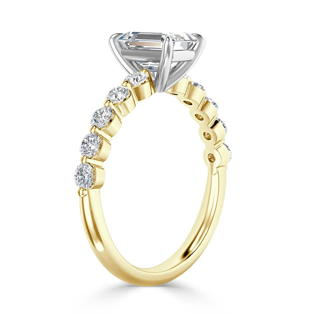 Gold ring with round diamonds set along the band and a large rectangular clear stone in a raised silver prong setting.