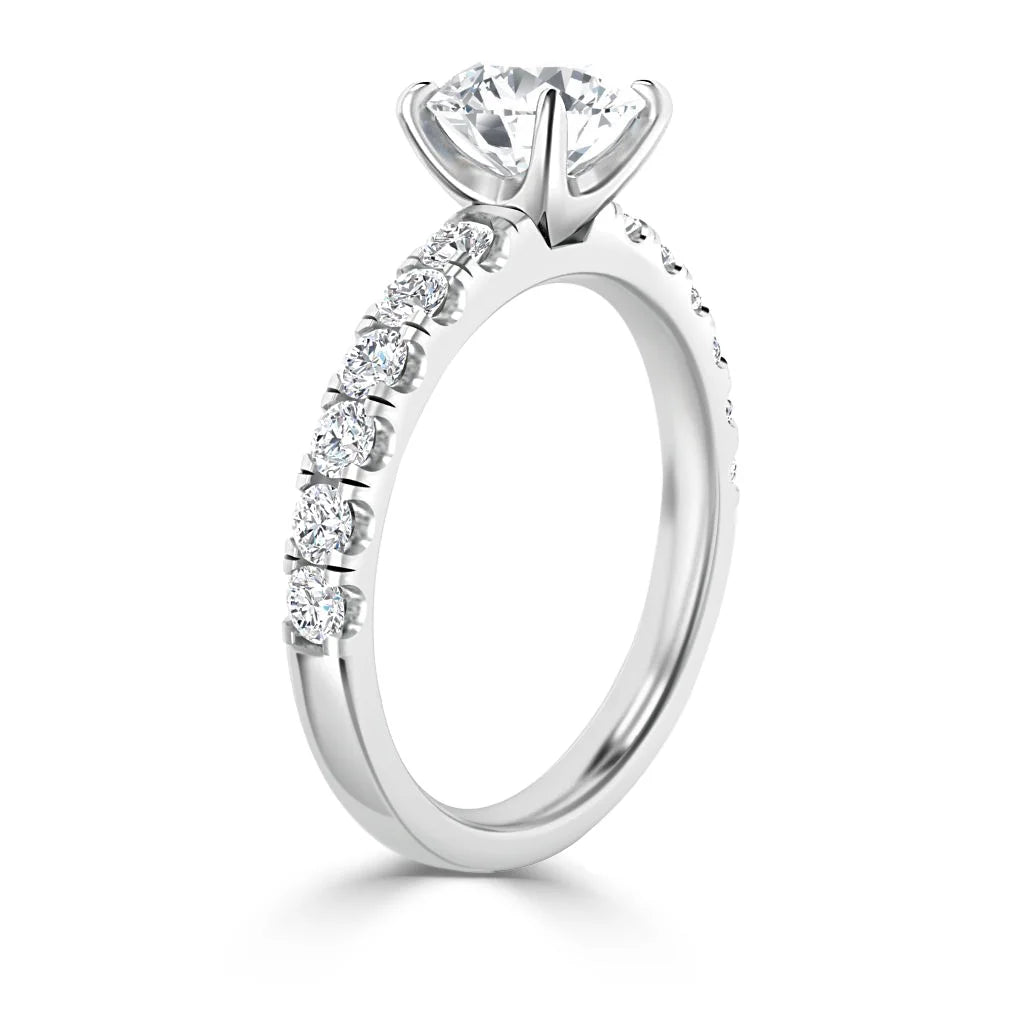 A white gold engagement ring with a large solitaire diamond and smaller diamonds on the band.