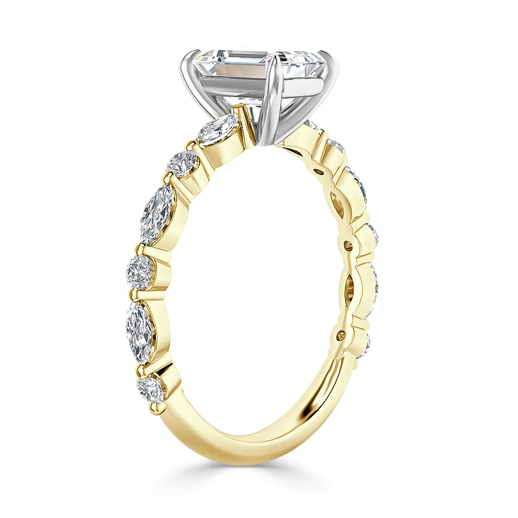 A gold ring with oval diamonds on the band and a large prong-set diamond centerpiece in a white gold setting.