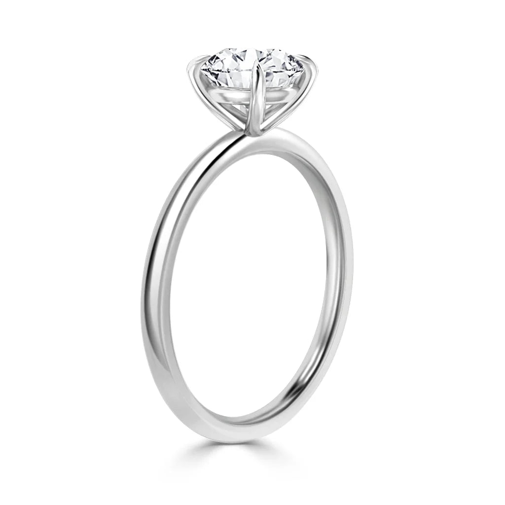A solitaire diamond ring with a thin silver band, shown from the side against a white background.