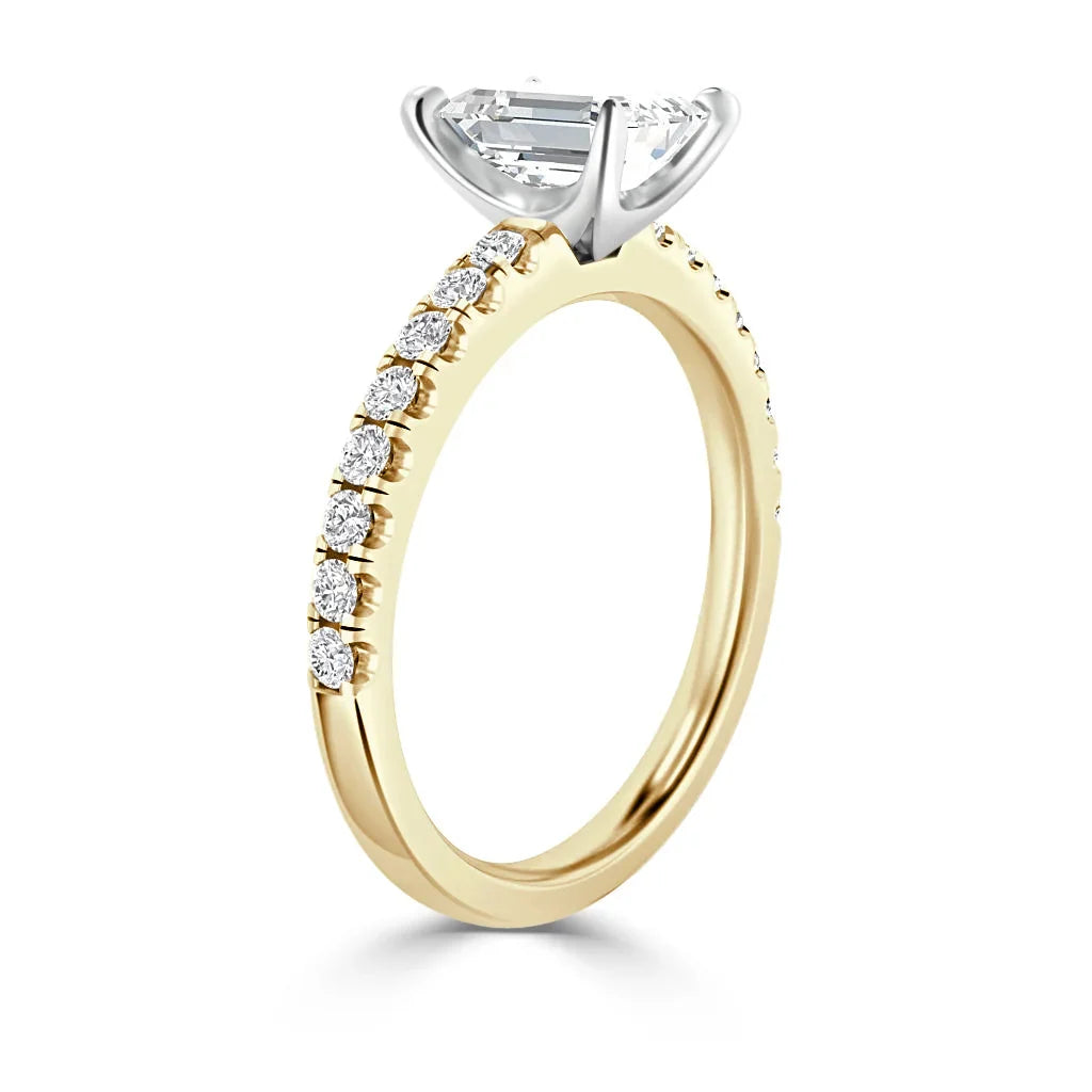 Yellow gold ring with a round diamond solitaire and small diamonds set along half of the band.
