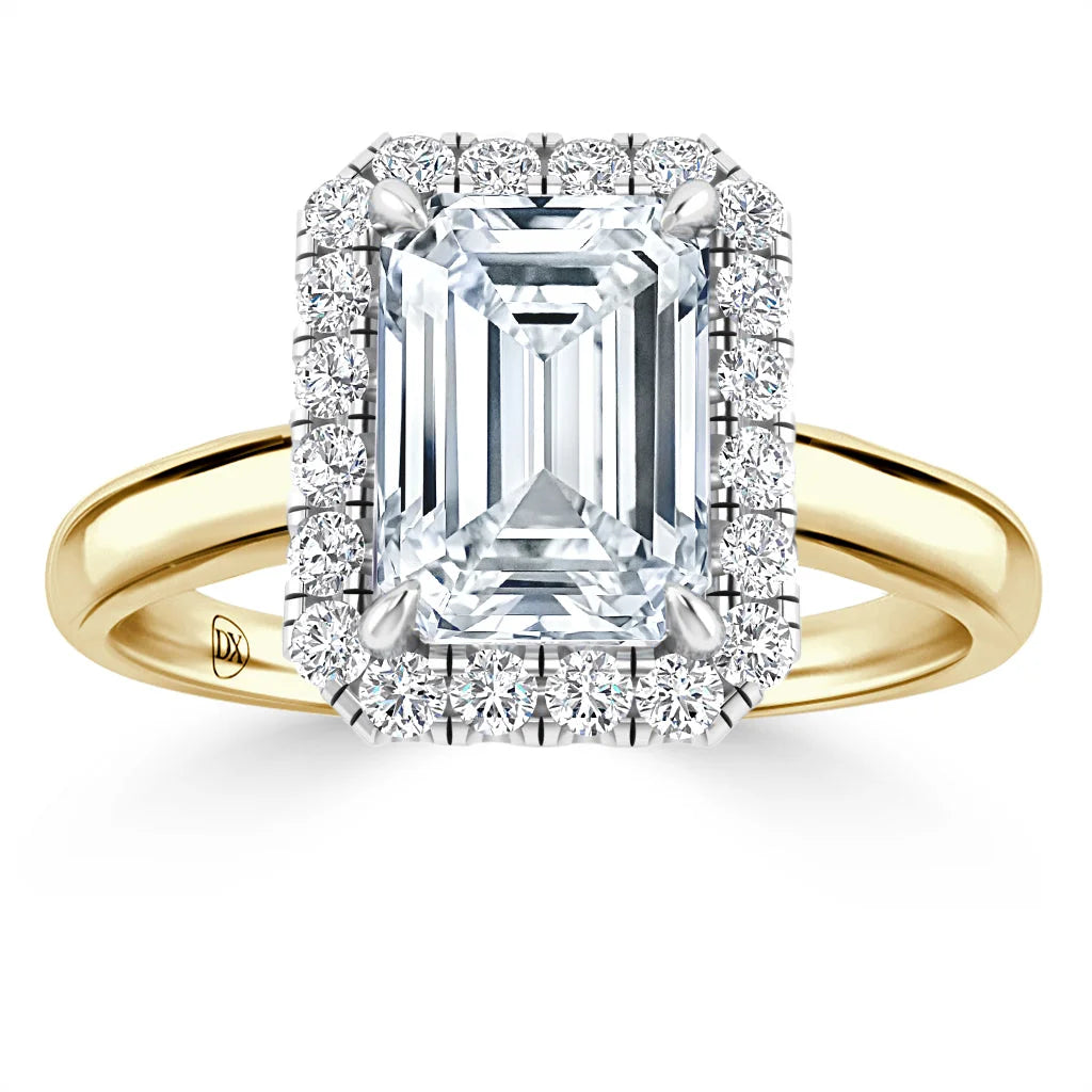 Emerald-cut diamond ring with a diamond halo on a yellow gold band, shown on a white background.
