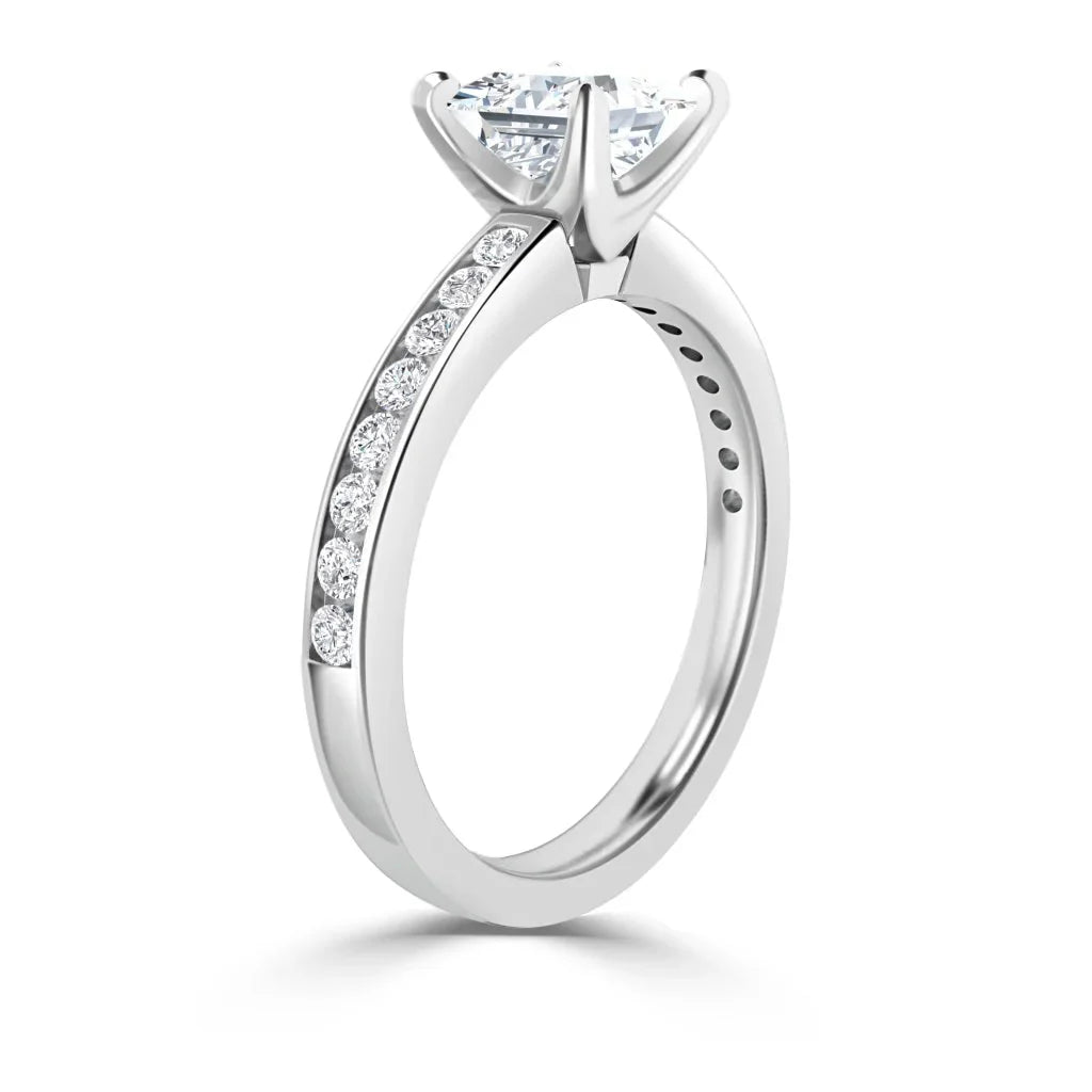 Elegant white gold ring with a round solitaire diamond and smaller diamonds set along the band.