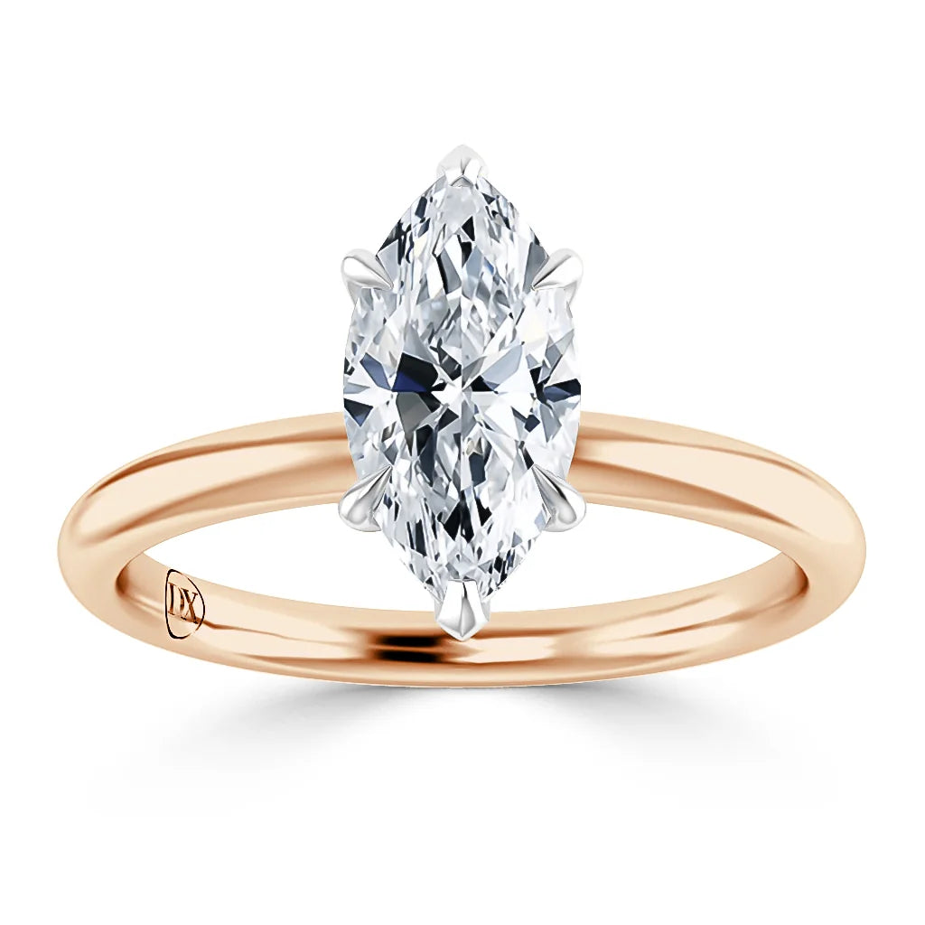 A marquise-cut diamond solitaire ring set on a simple rose gold band against a white background.
