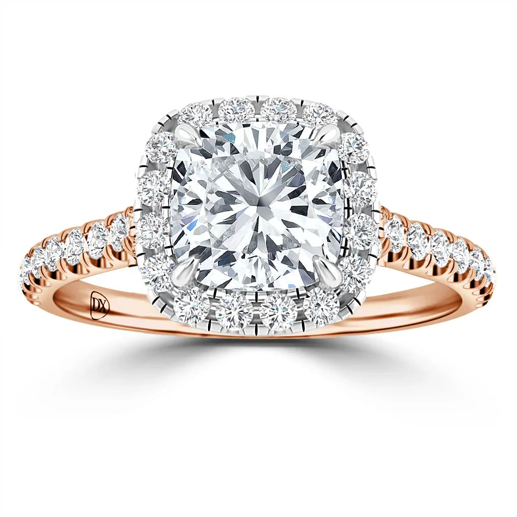 A rose gold ring with a cushion-cut diamond center, surrounded by a halo and pavé diamonds on the band.