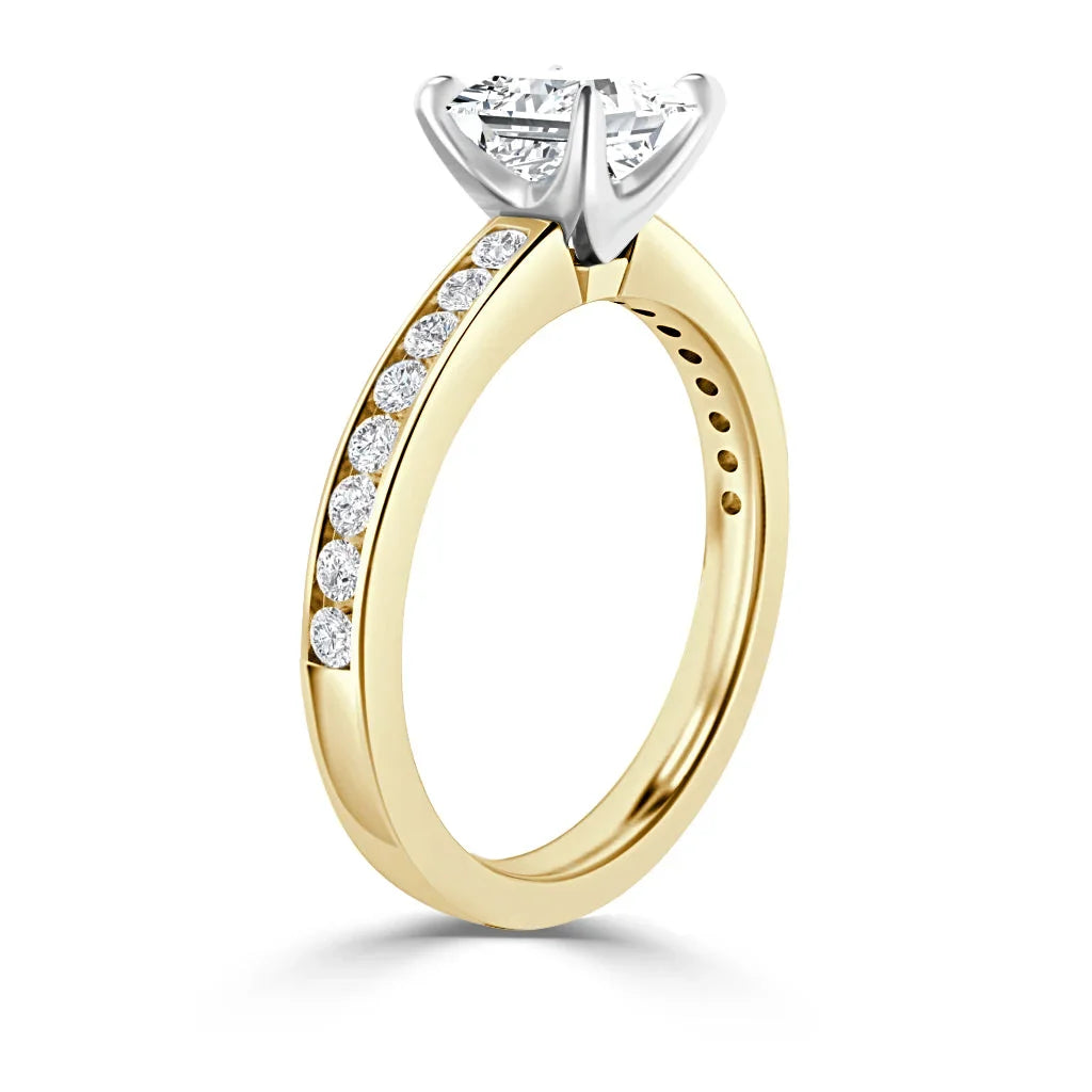 Yellow gold ring with side diamonds and a large round center diamond in a white gold prong setting.