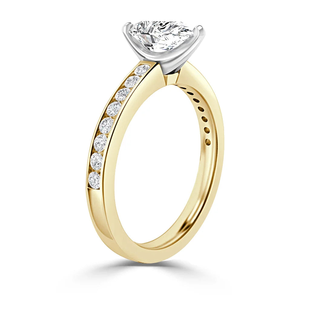 Gold ring with round diamond solitaire and side diamonds set into the band, shown on a white background.