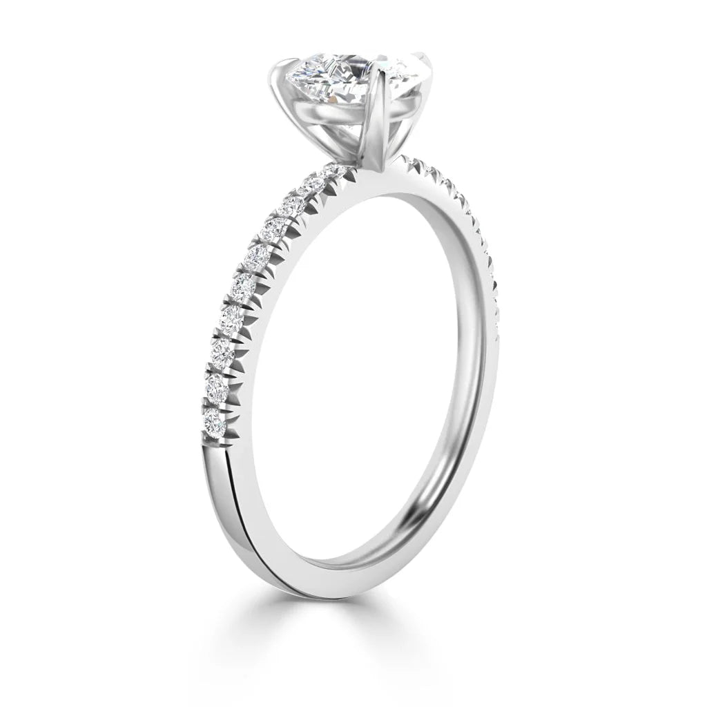 White gold ring with round solitaire diamond and small diamonds along the band, set against a white background.