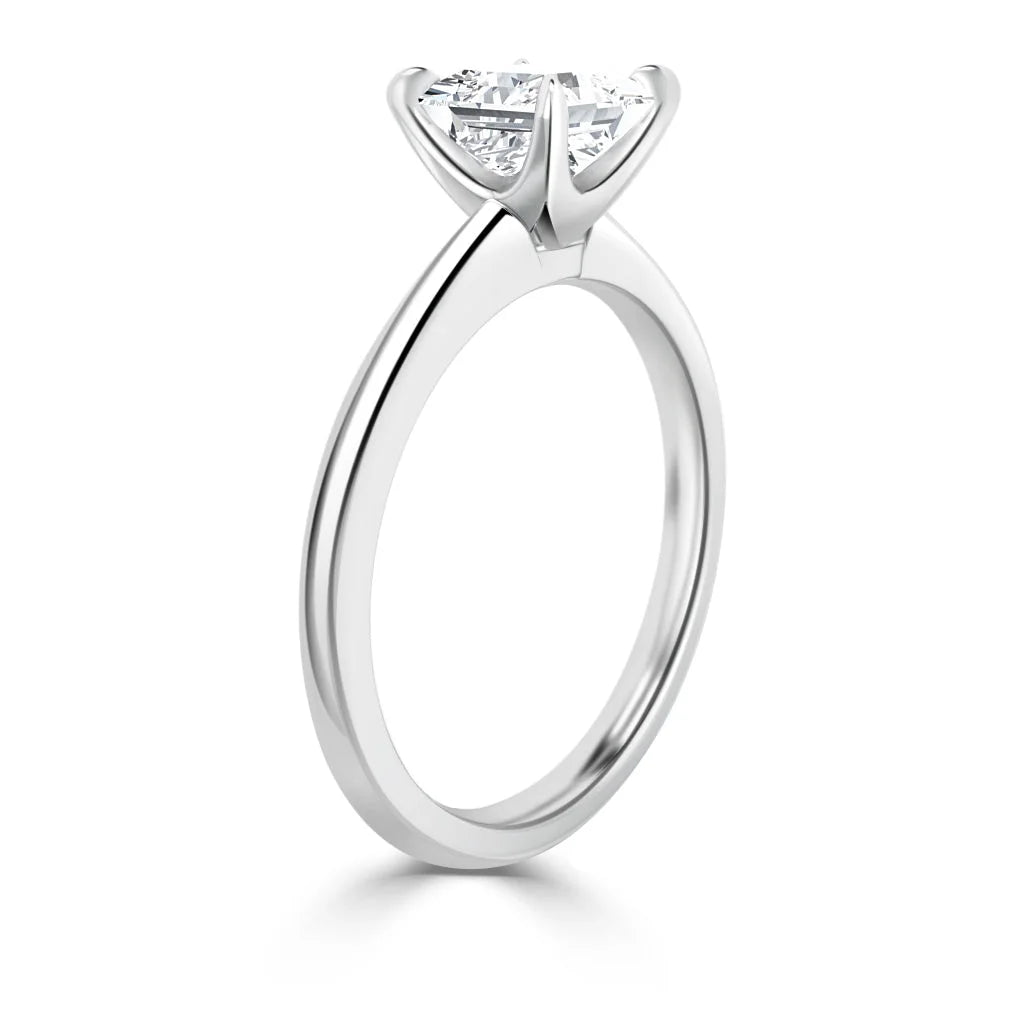 A solitaire diamond ring with a round stone set in a four-prong white gold or platinum band.