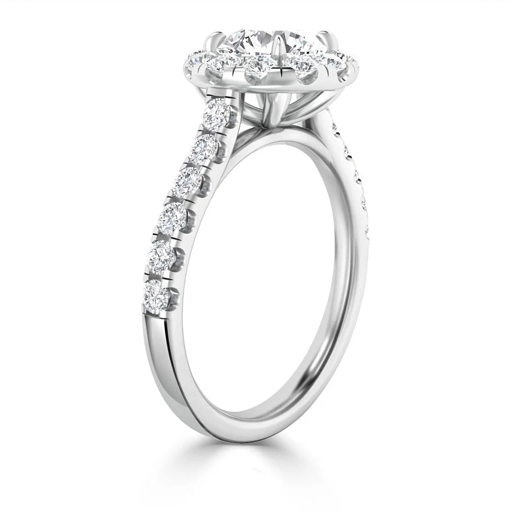 White gold ring with a round halo diamond setting and diamonds along the band, shown from a side angle.