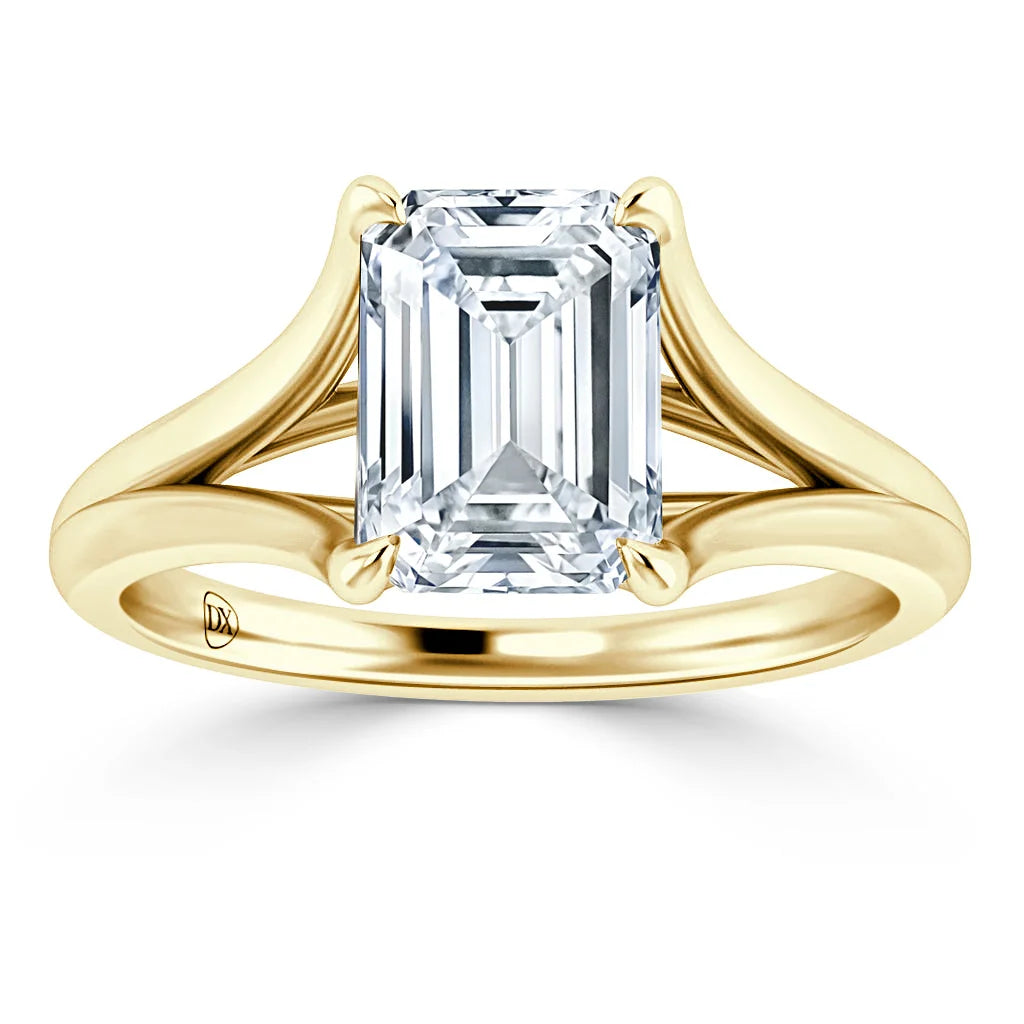 A gold ring with a split shank band, featuring a large emerald-cut diamond in a prong setting.