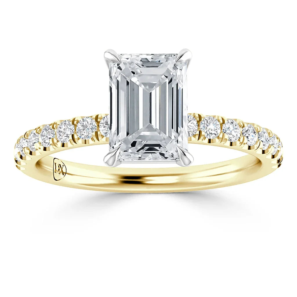 Emerald-cut diamond ring with a gold band, accented by smaller diamonds along the band.