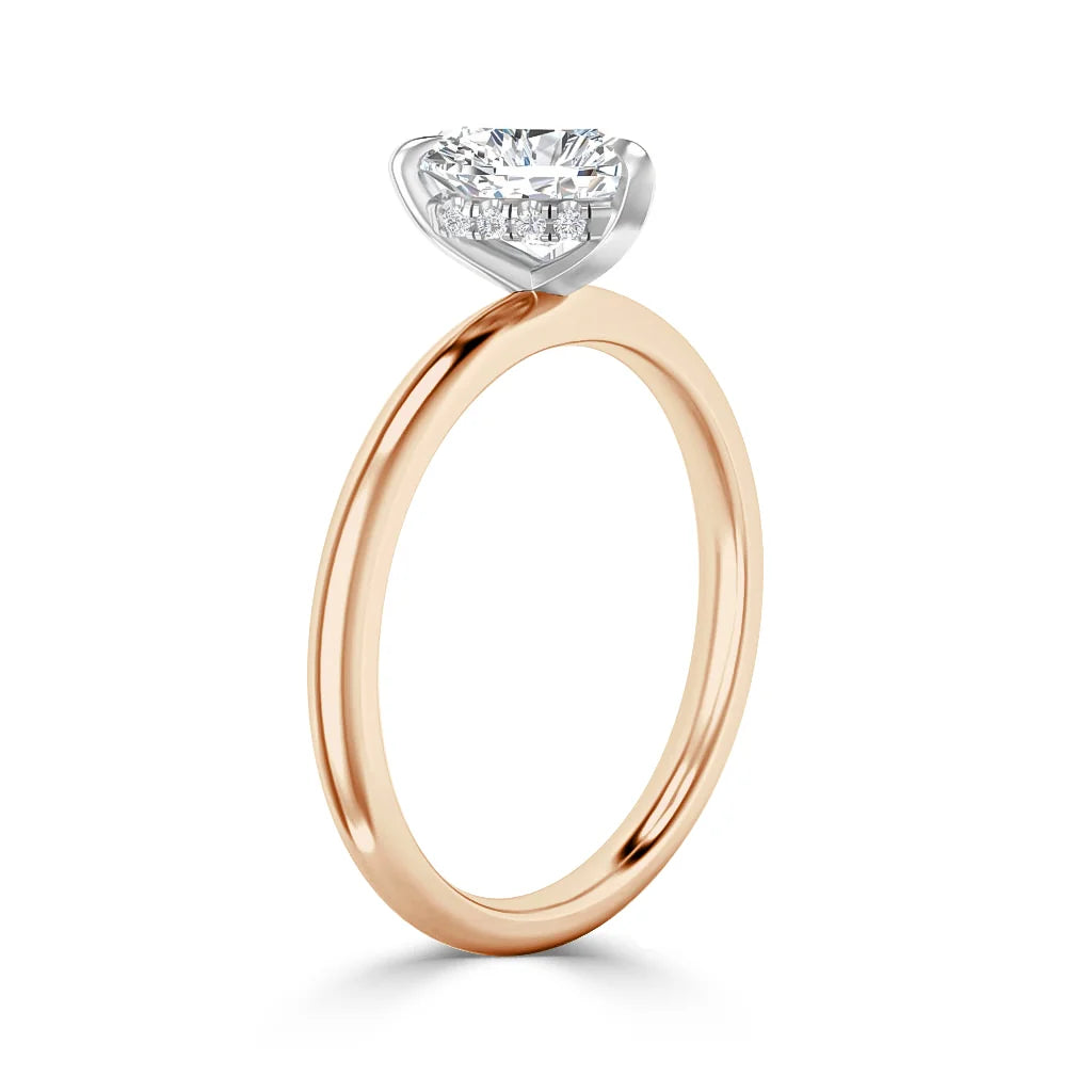 A rose gold ring with a round, prong-set diamond solitaire on a simple thin band, shown in profile.