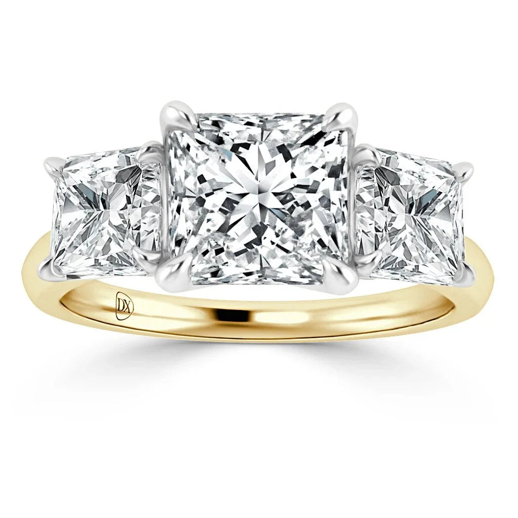 Gold ring with three princess-cut diamonds, the center diamond larger than the two side diamonds.