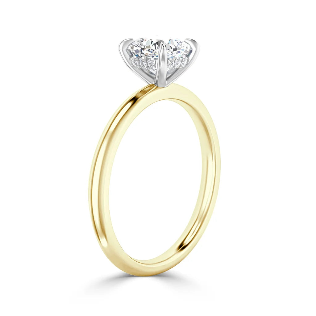 A gold band engagement ring with a round, prong-set diamond solitaire on a white background.