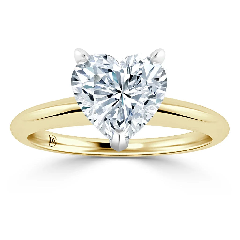 Heart-shaped diamond ring with a yellow gold band and prong setting on a white background.
