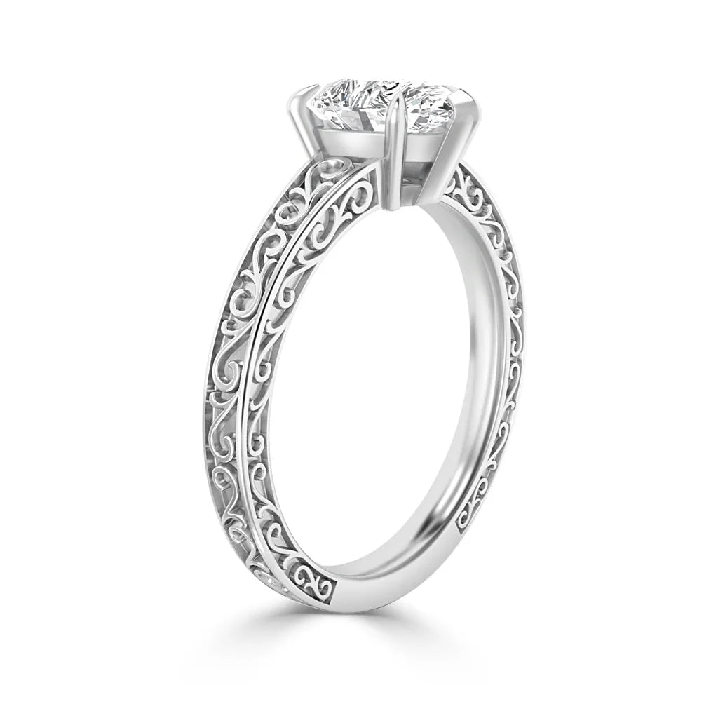 White gold ring with intricate filigree band and a large round diamond in a four-prong setting.