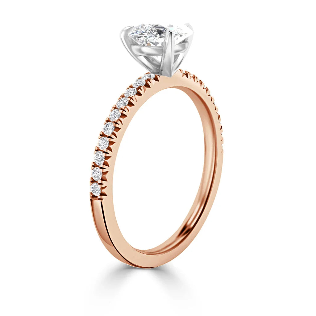 Rose gold ring with a row of small diamonds and a large round diamond in a prong setting on top.