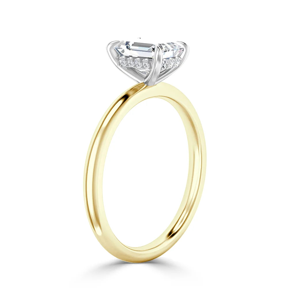 A gold ring with a large rectangular diamond and small accent diamonds set in a white gold prong setting.