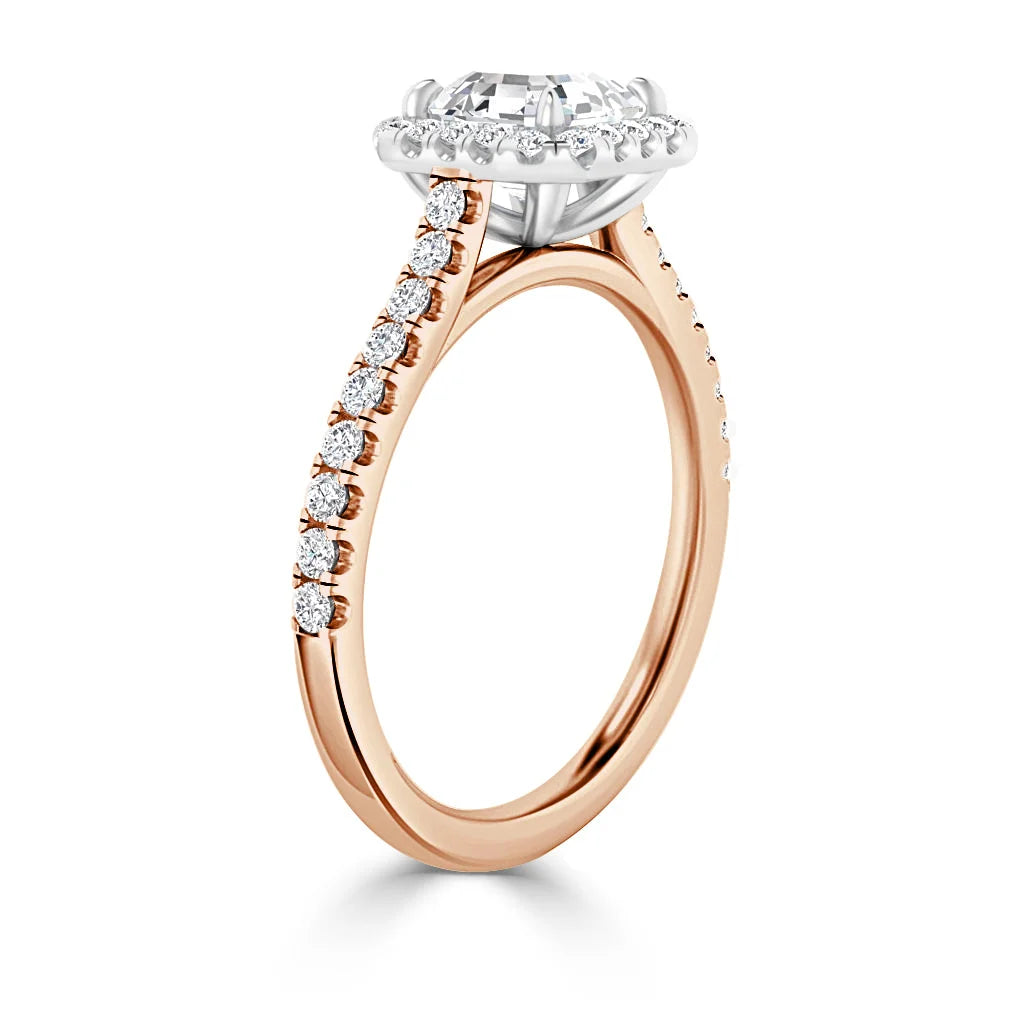 A rose gold ring with a round diamond center, halo setting, and diamond accents along the band.