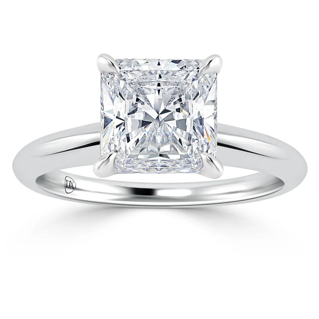 A silver ring with a large, square-cut diamond in a four-prong setting on a plain band.