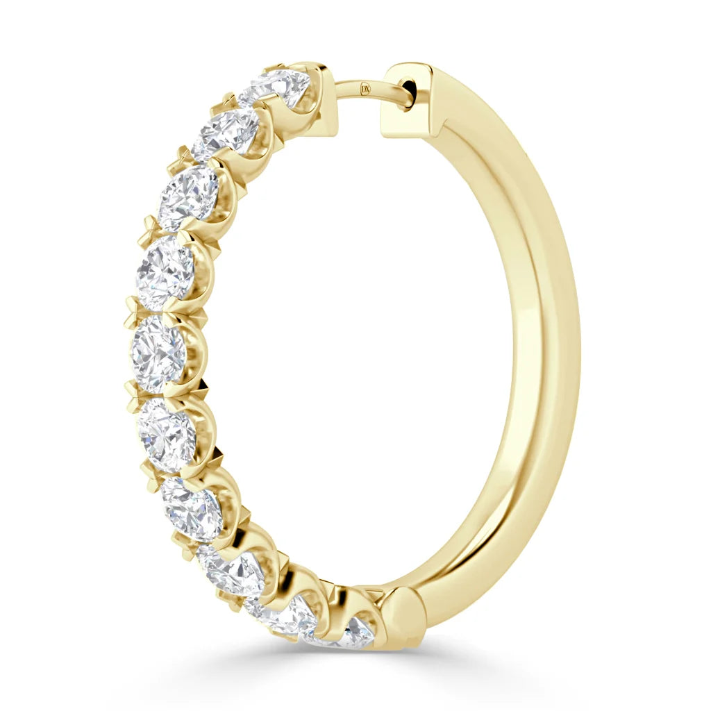 Gold hoop earring with round white diamonds set along the front, shown against a white background.