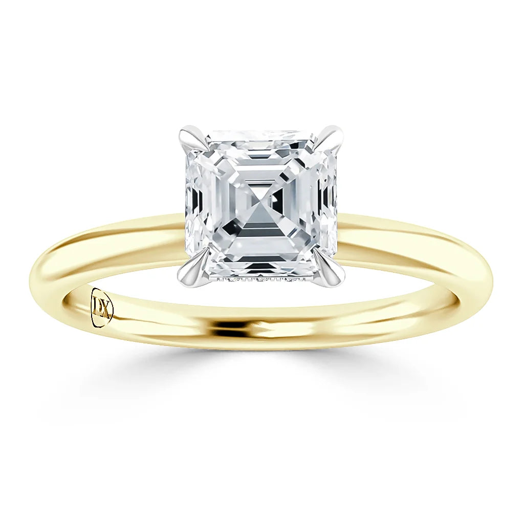 Gold band ring with a square-cut diamond solitaire set in four prongs, shown on a white background.