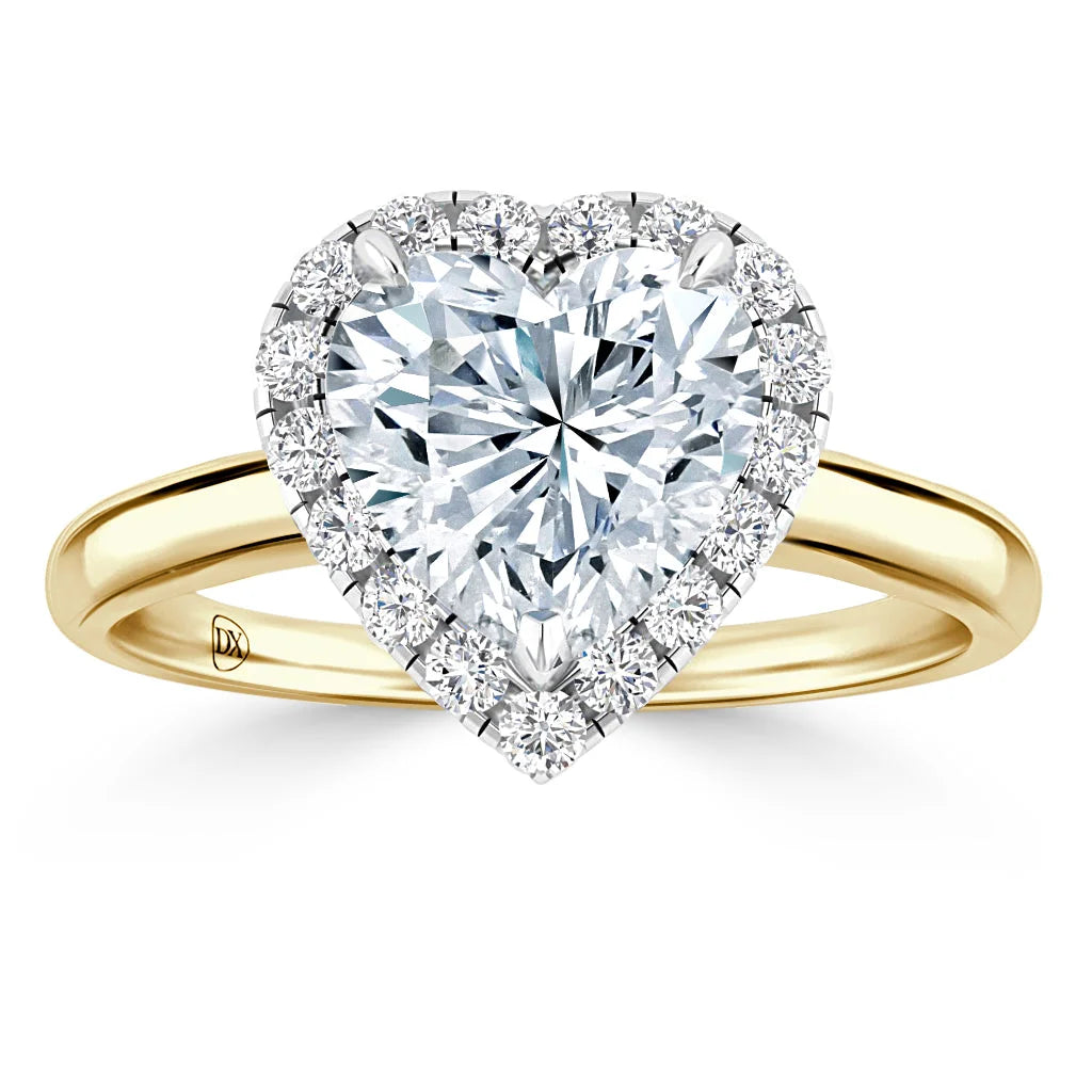 Heart-shaped diamond ring with a gold band and a halo of small round diamonds around the center stone.