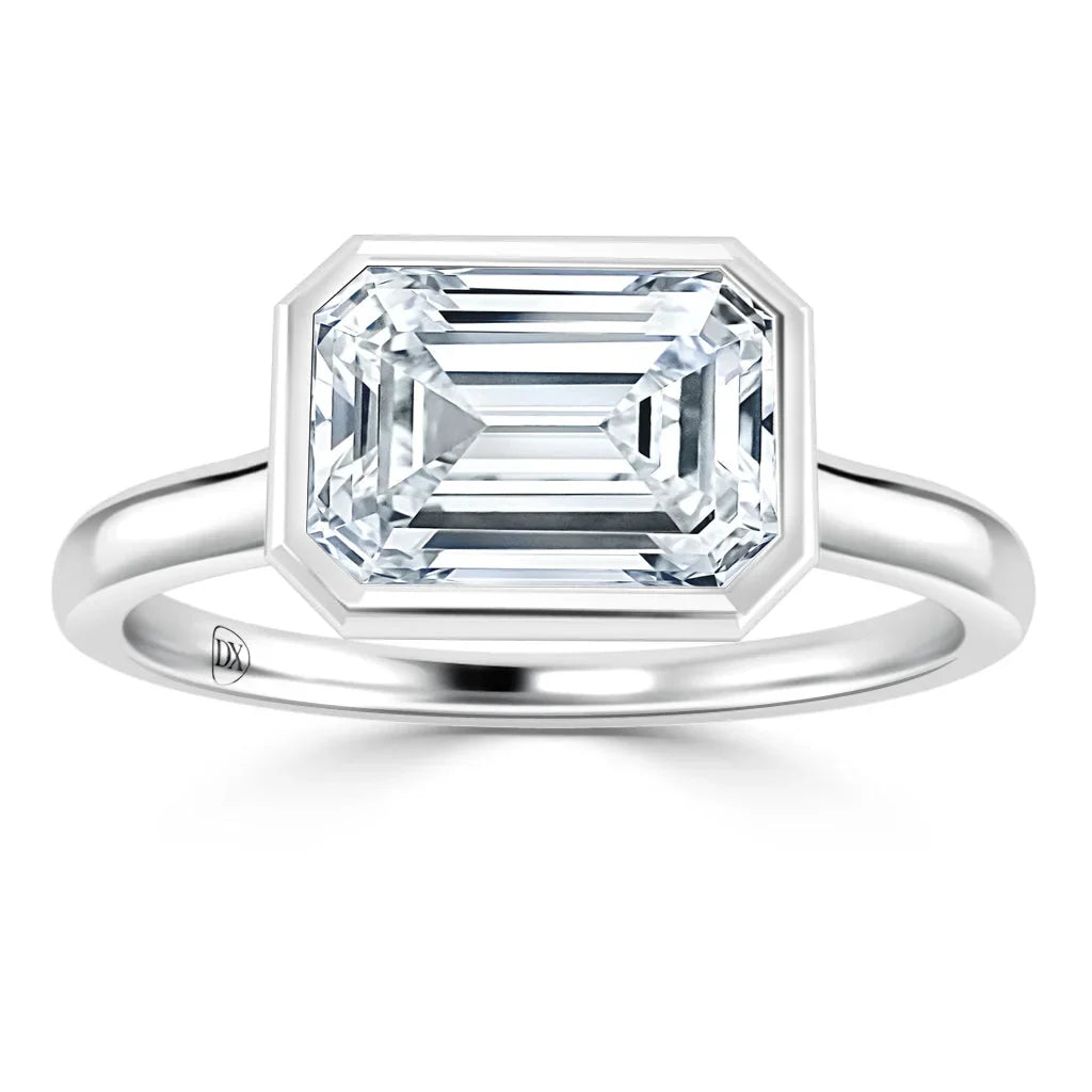 Emerald-cut diamond ring with a sleek bezel setting on a polished silver band, shown on a white background.