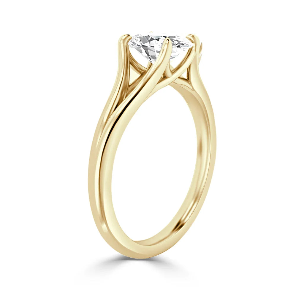 A gold ring with a round, prong-set diamond solitaire in an elegant, twisting band design.