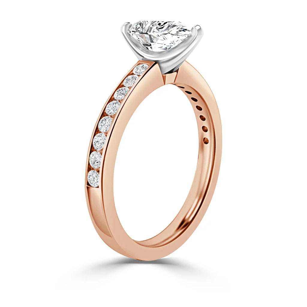 Rose gold ring with diamond accents on the band and a large solitaire diamond in a prong setting.