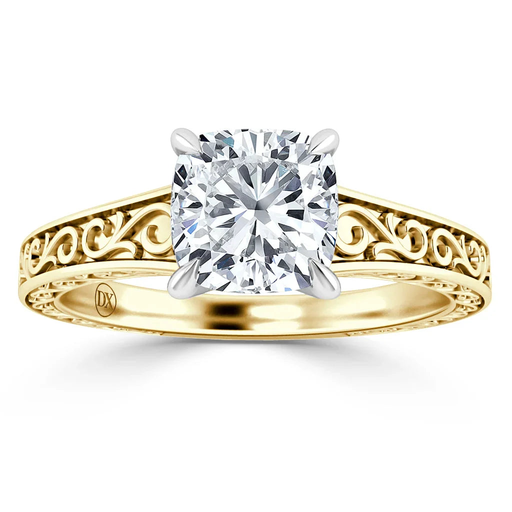 Gold ring with a large cushion-cut diamond and intricate, swirling filigree design on the band.