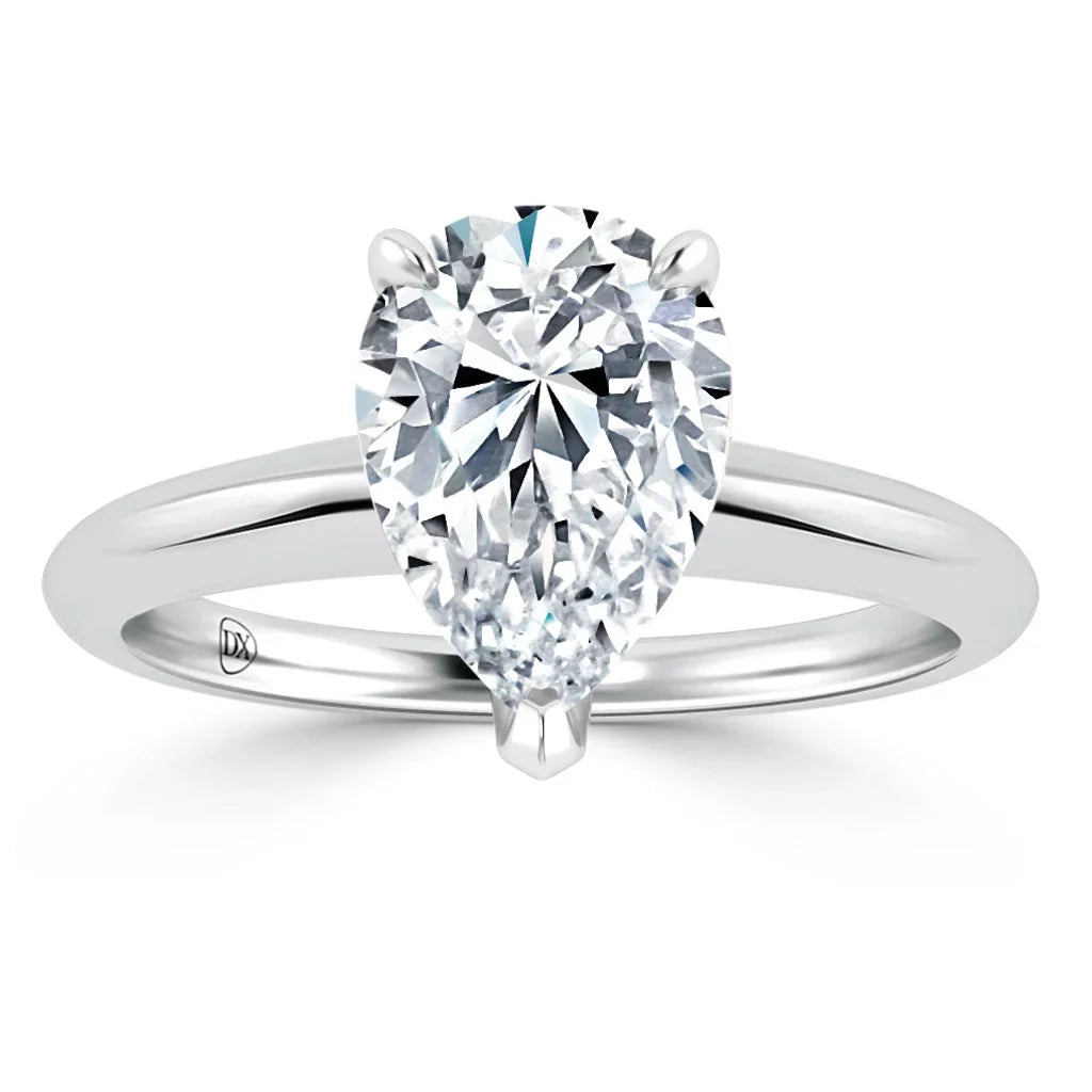 A pear-shaped diamond solitaire ring with a polished silver band set against a white background.