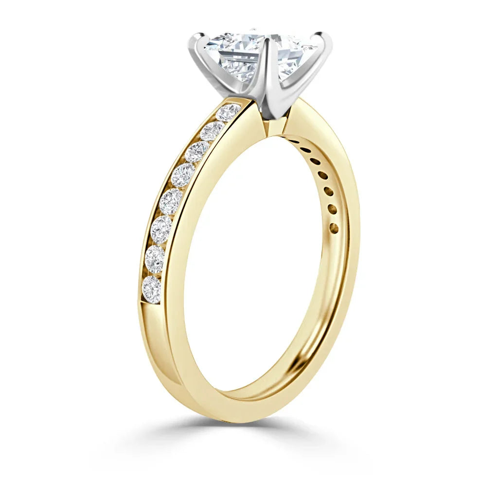 Gold ring with a round, prong-set diamond and smaller diamonds embedded along the band.
