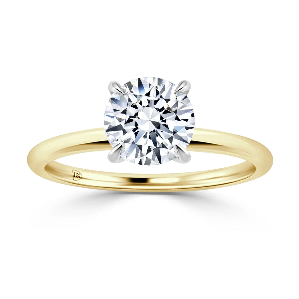 A gold band ring with a large, round, brilliant-cut diamond set in a four-prong setting on a white background.