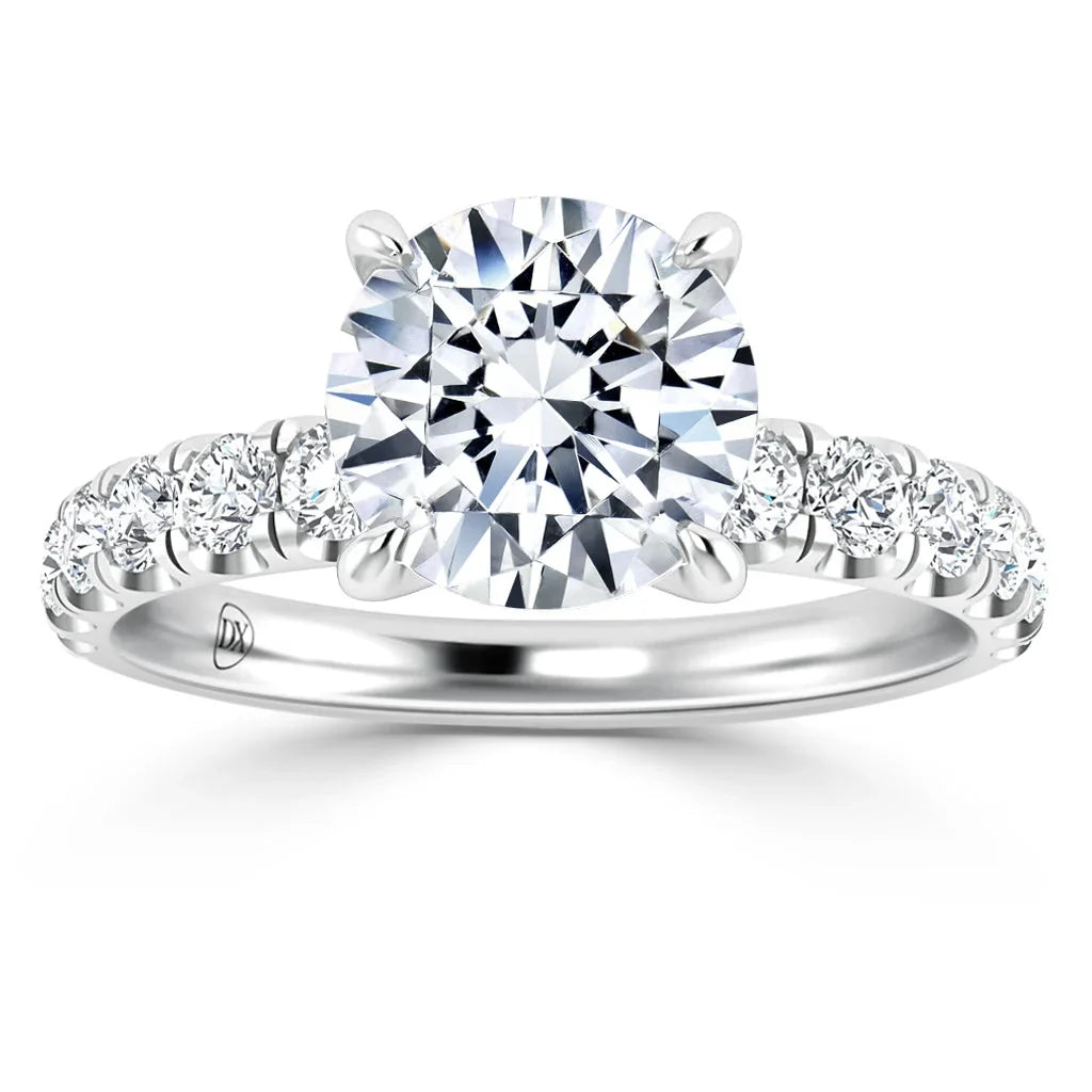 A platinum ring with a large round diamond center stone and smaller diamonds along the band.