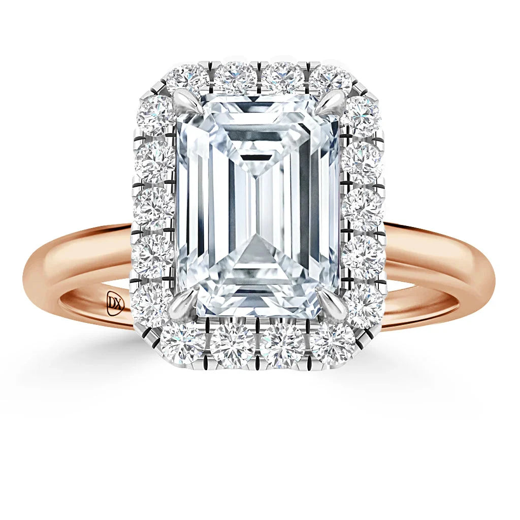 A rose gold ring with a large emerald-cut diamond center, surrounded by a halo of round diamonds.