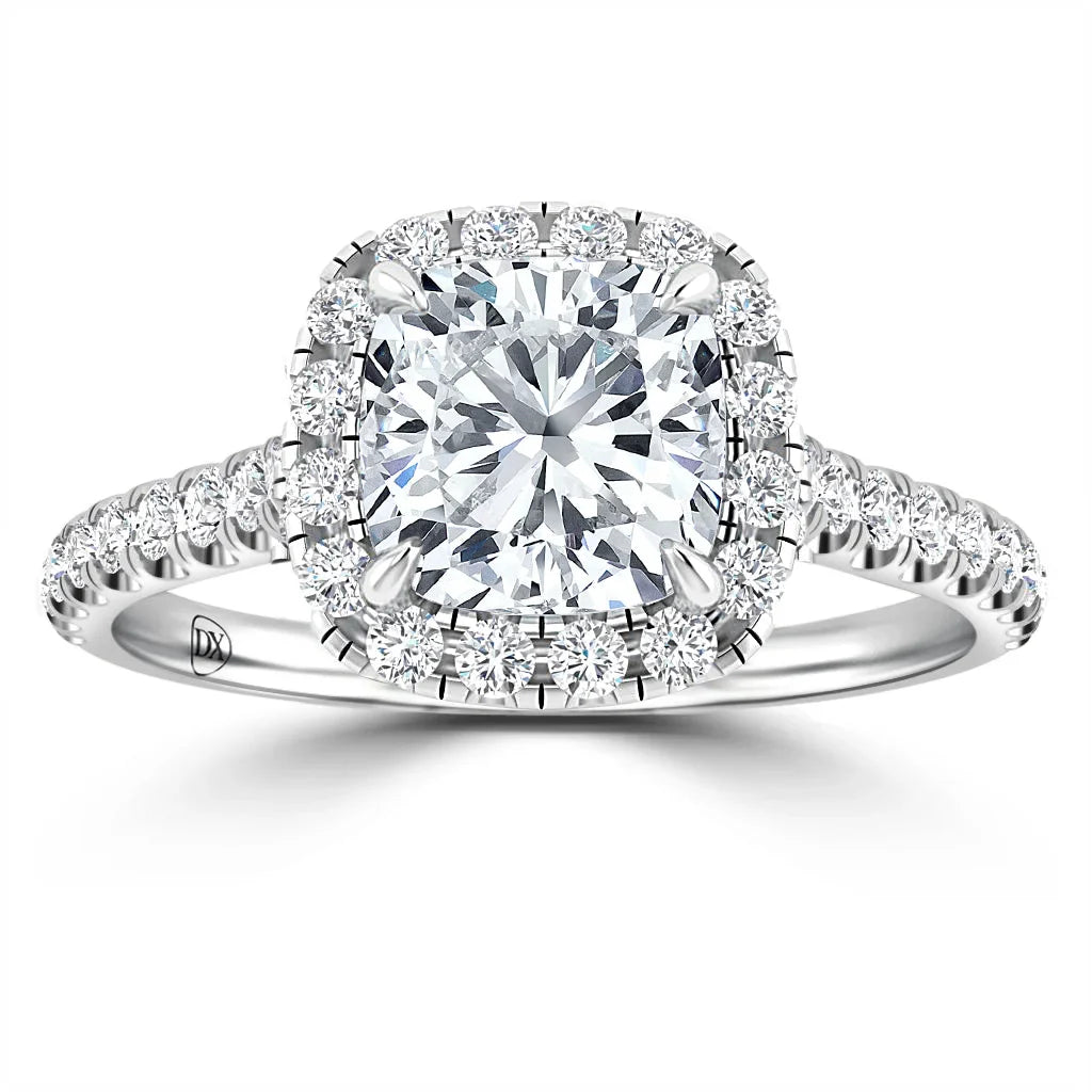 A cushion-cut diamond ring with a halo and pavé diamond band on a white gold setting.