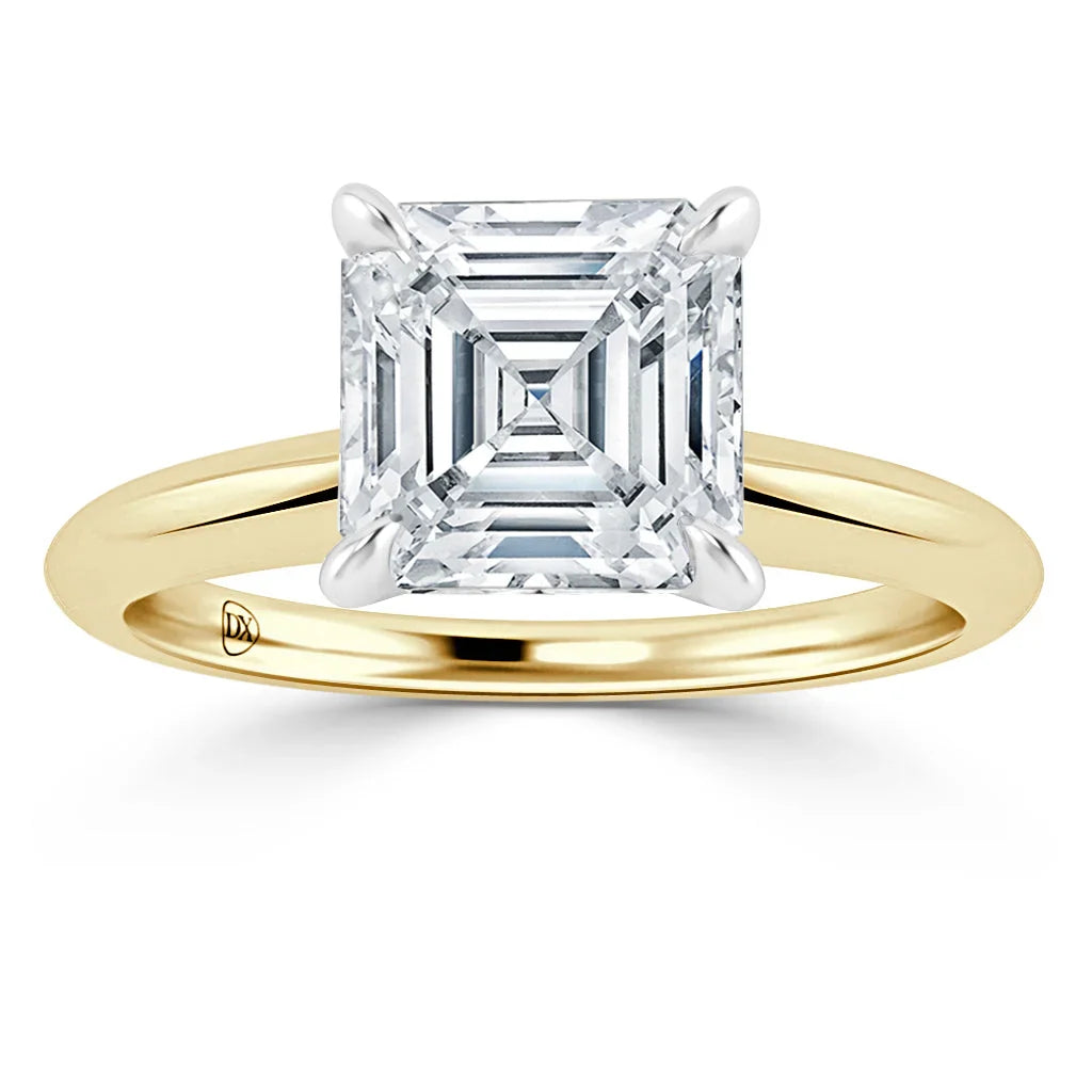 A gold ring with a large, square-cut diamond set in a four-prong setting on a plain band.