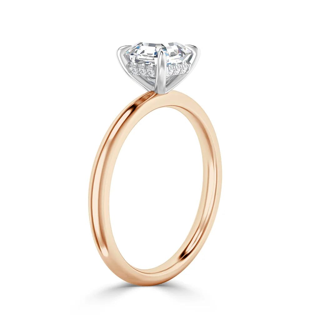 A rose gold ring with a round solitaire diamond set in a white gold prong setting, shown from the side.