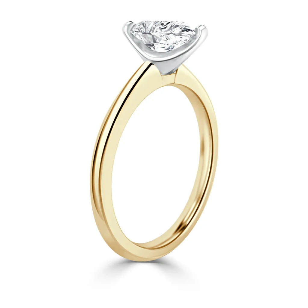 Gold ring with a round diamond solitaire in a white prong setting, viewed from the side against a white background.