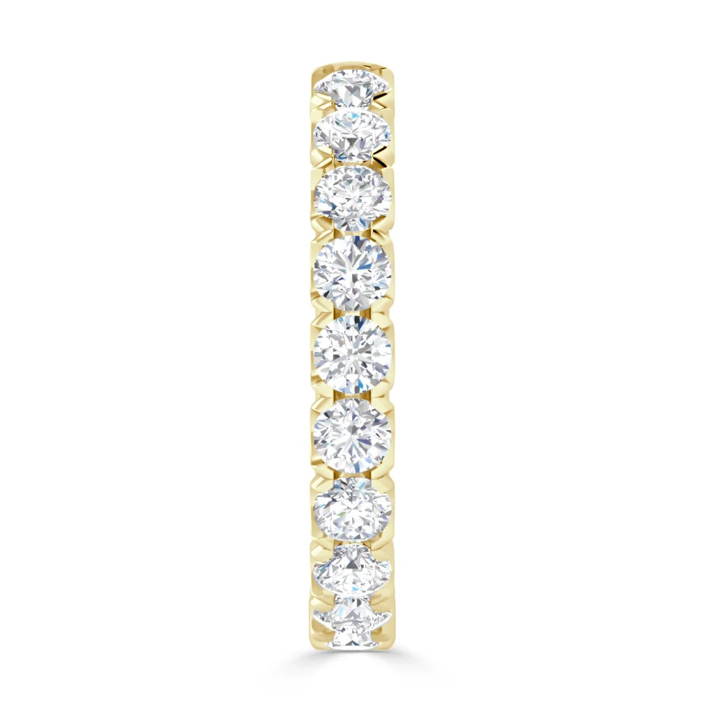 A gold ring set with seven round, sparkling diamonds in a vertical row on a white background.