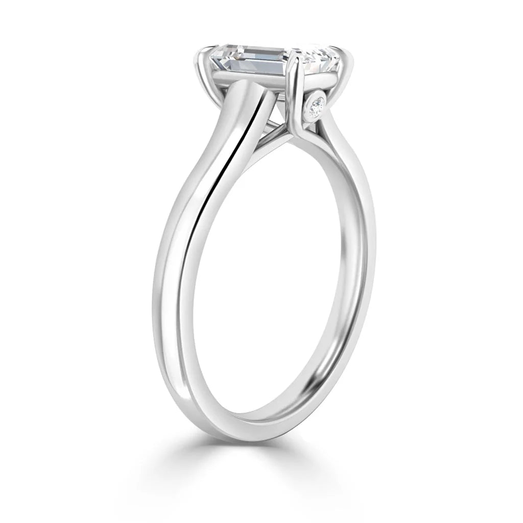 A white gold solitaire engagement ring with a round diamond in a prong setting, viewed from the side.