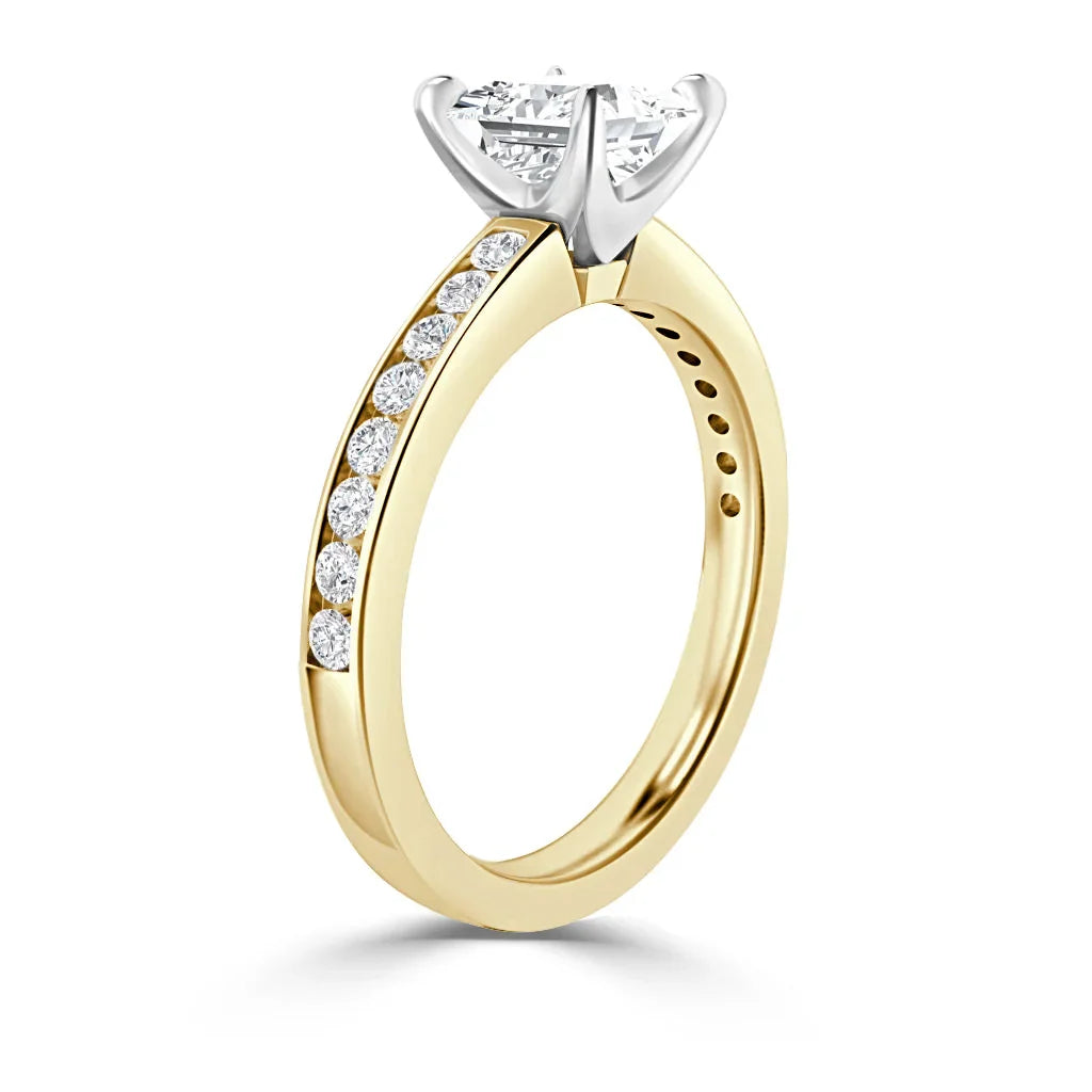 A gold ring with a large round diamond solitaire and smaller diamonds set along the band, on a white background.
