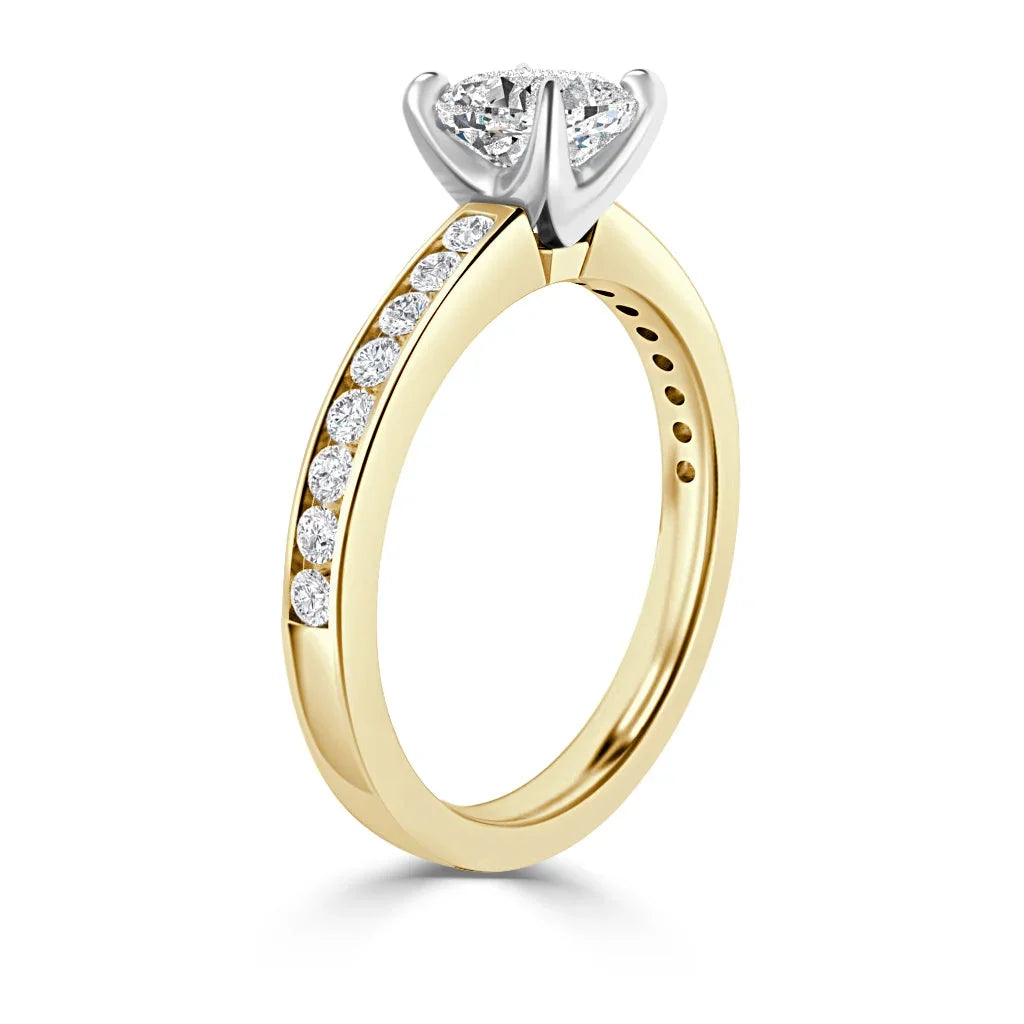 Gold ring with a row of small diamonds on the band and a large single diamond in a silver prong setting.