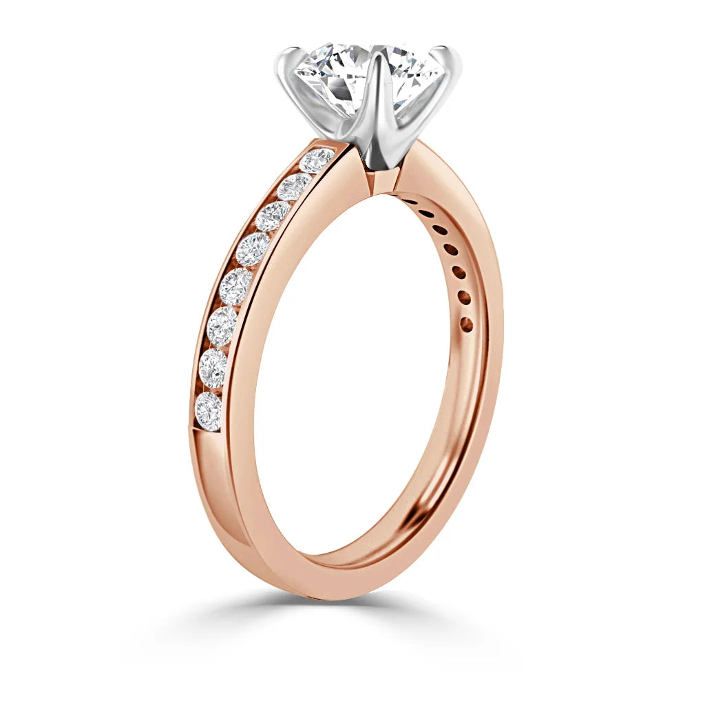 A rose gold ring with a round solitaire diamond and side diamonds set along the band.