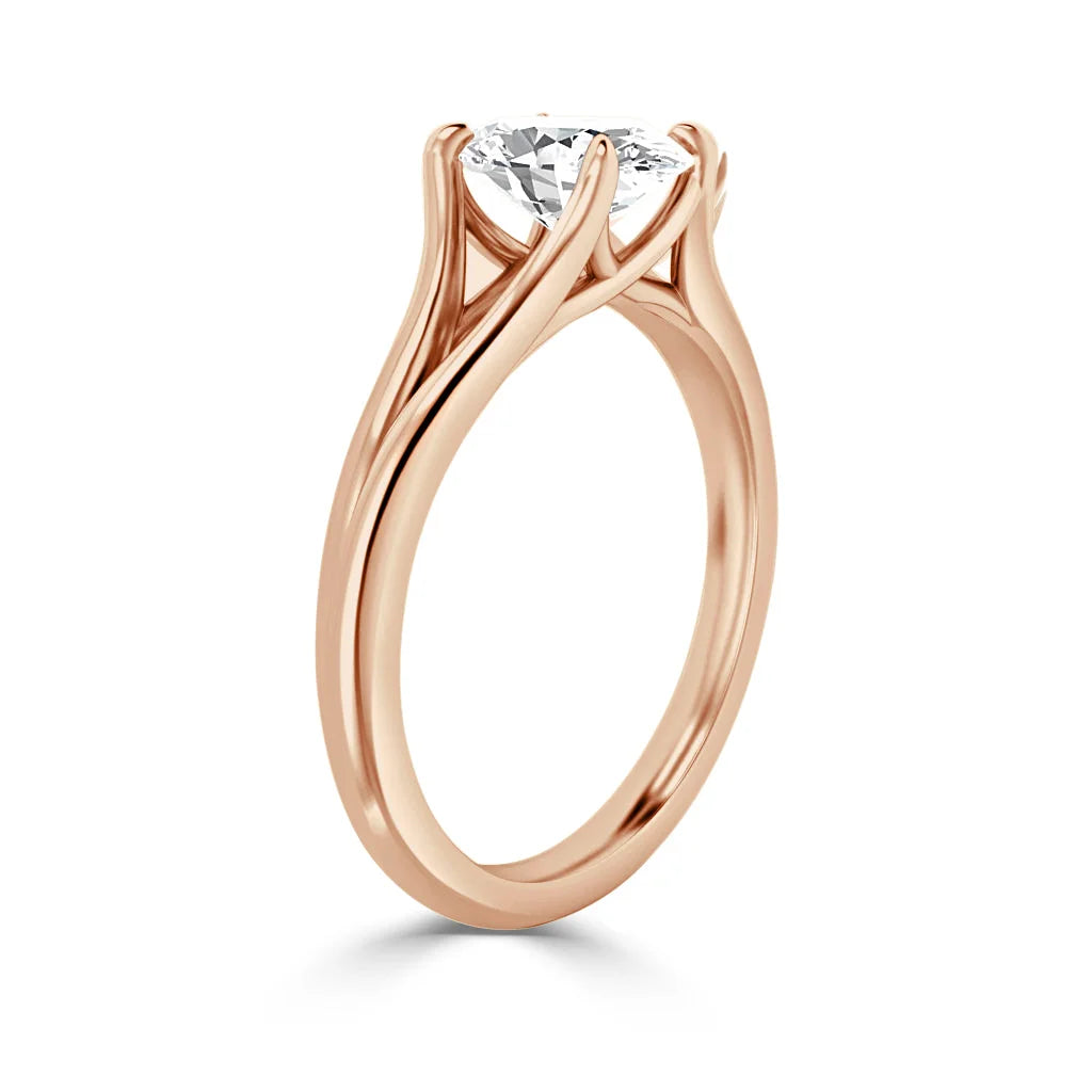 Rose gold ring with an elegant twisted band and a round solitaire diamond set in a four-prong setting.